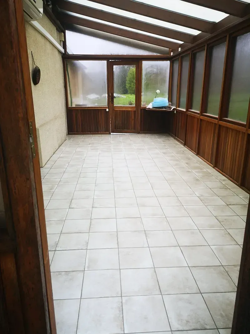 Carrelage clair posé au sol d'une véranda en Normandie
