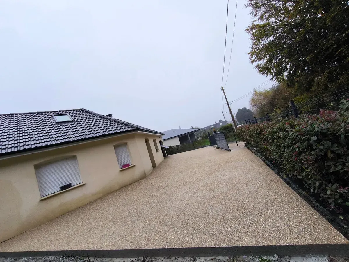 Allée latérale en béton désactivé ton sable le long d'une maison en Seine-Maritime